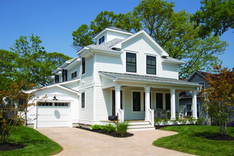 Modern coastal home at 209 River Ave, Point Pleasant Beach, featuring white Hardie Plank siding, black framed windows, and a metal roof