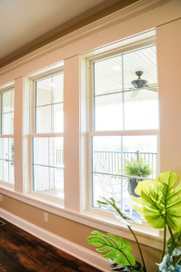 Three white double-hung windows with a classic grid pattern in a bright living room